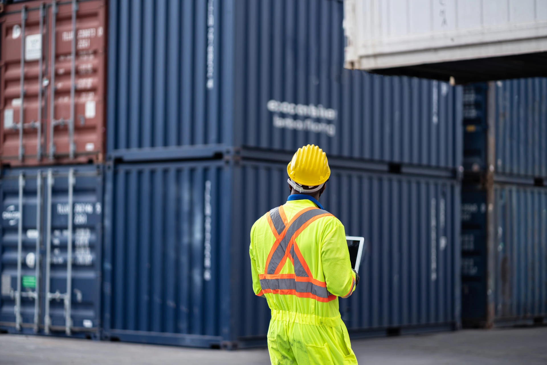 Homme en tenue de travail entouré de containers