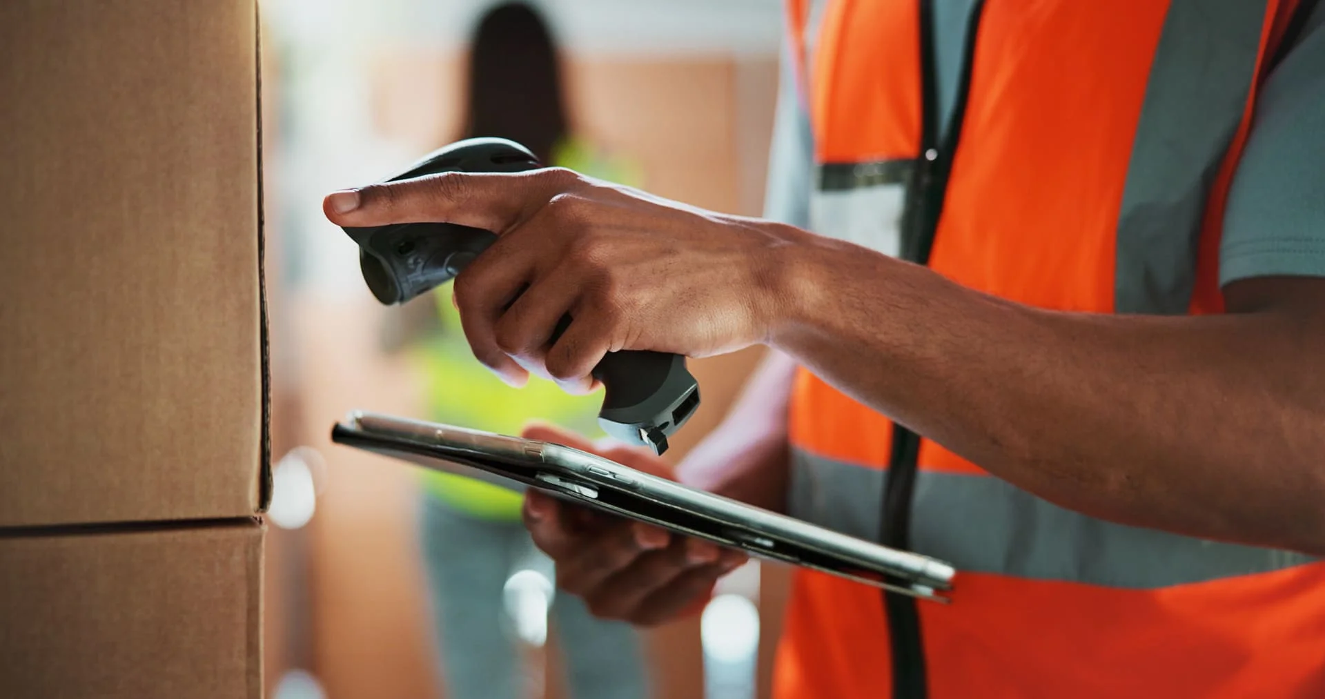Personne avec une scannette et une tablette dans les mains pour effectuer le suivi d'un coli